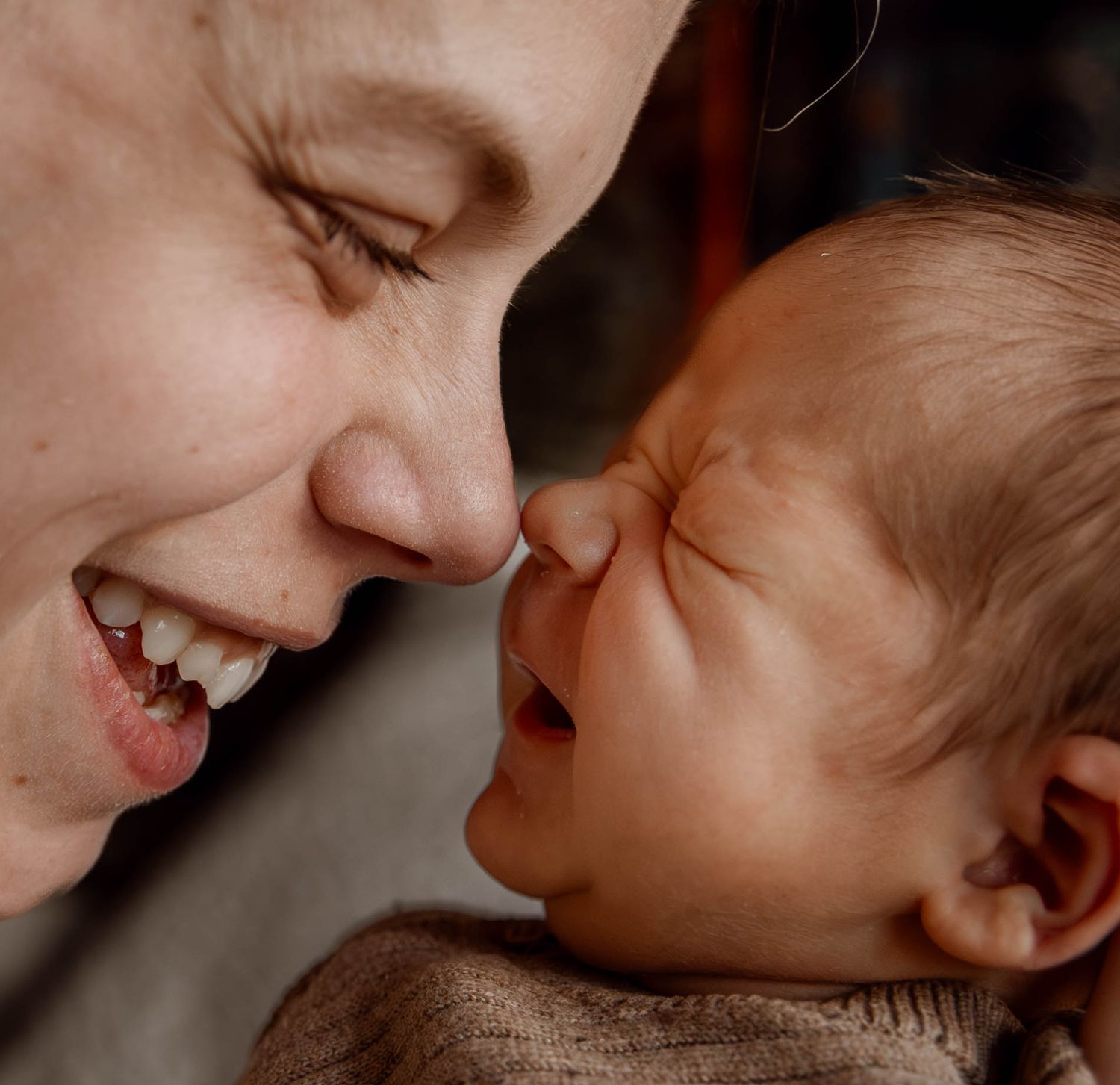 Intimate moment of shared laughter and joy between parent and baby.
