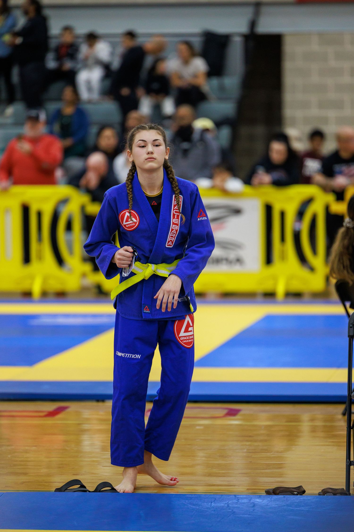 BJJ competitor in blue gi warming up preparing for tournament match. Gracie Barra