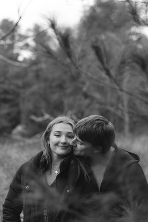 A romantic black and white photo series showing a couple sharing intimate moments together in nature.