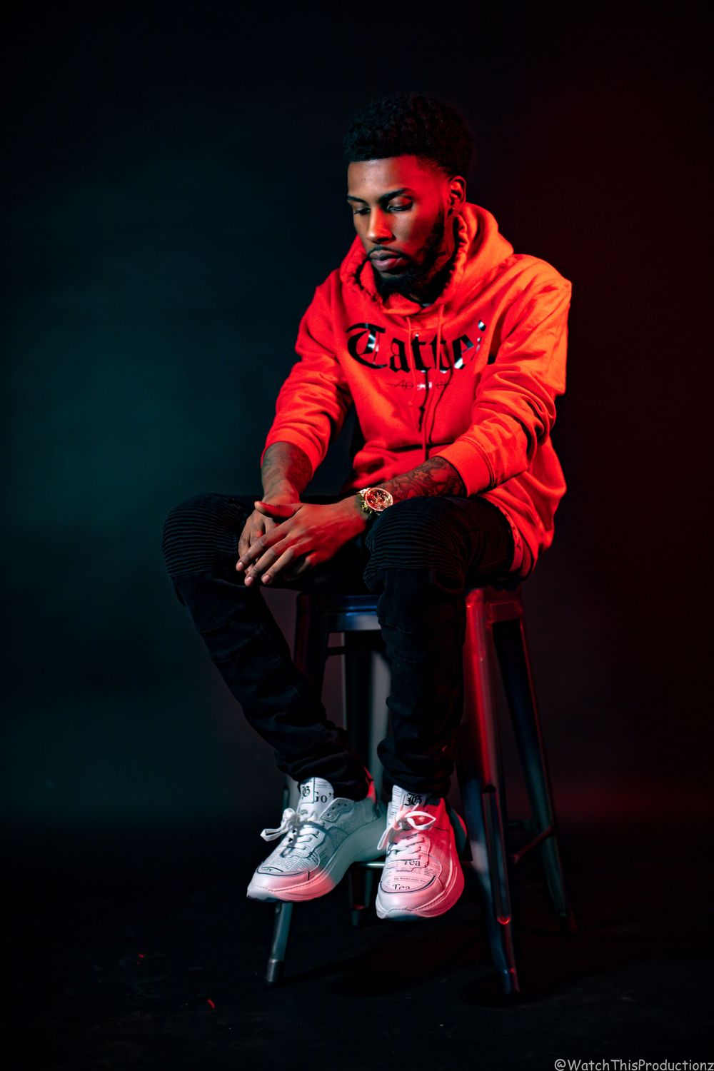 Artistic portrait series in red hoodie against dark background.