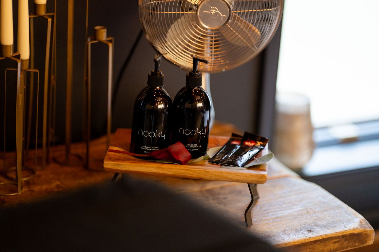 Dark wine bottles displayed on wooden surface with electric fan in background.
