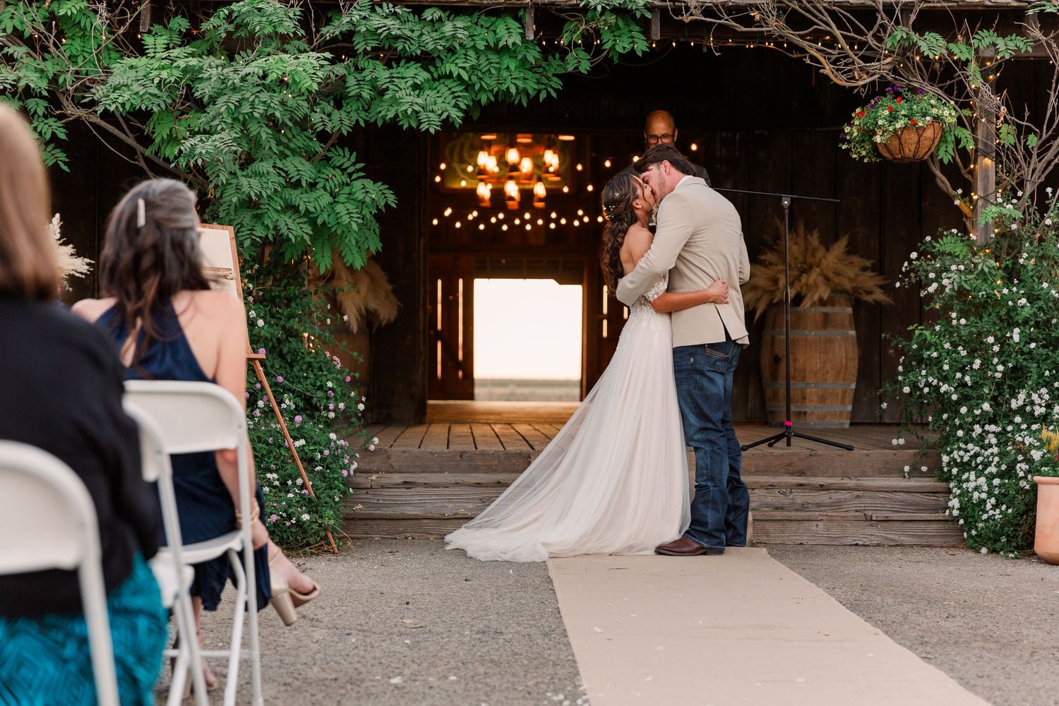 Wedding ceremony moments captured at a rustic venue with string lights and wooden details.