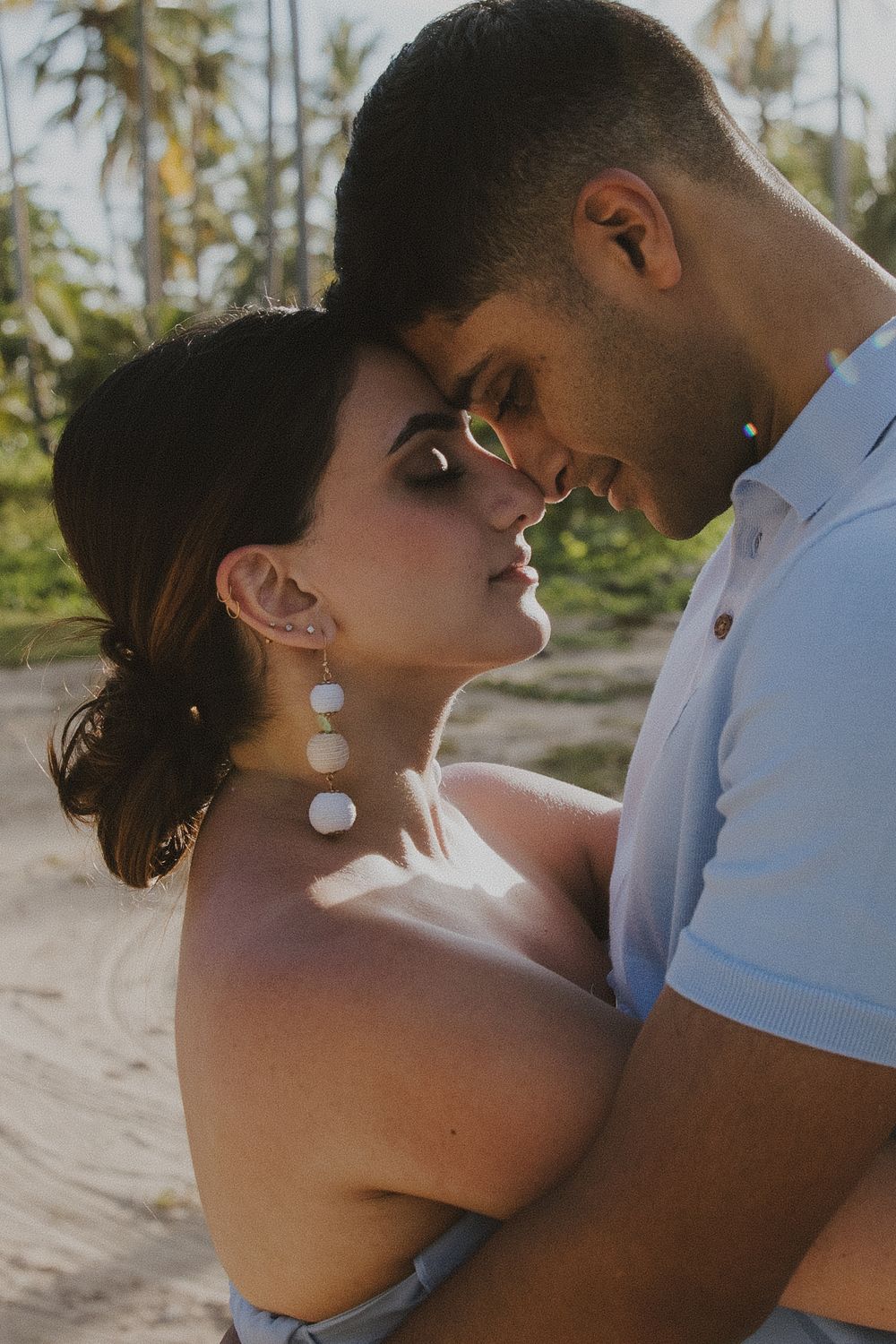 A romantic tropical beach portrait with palm trees in the background.
