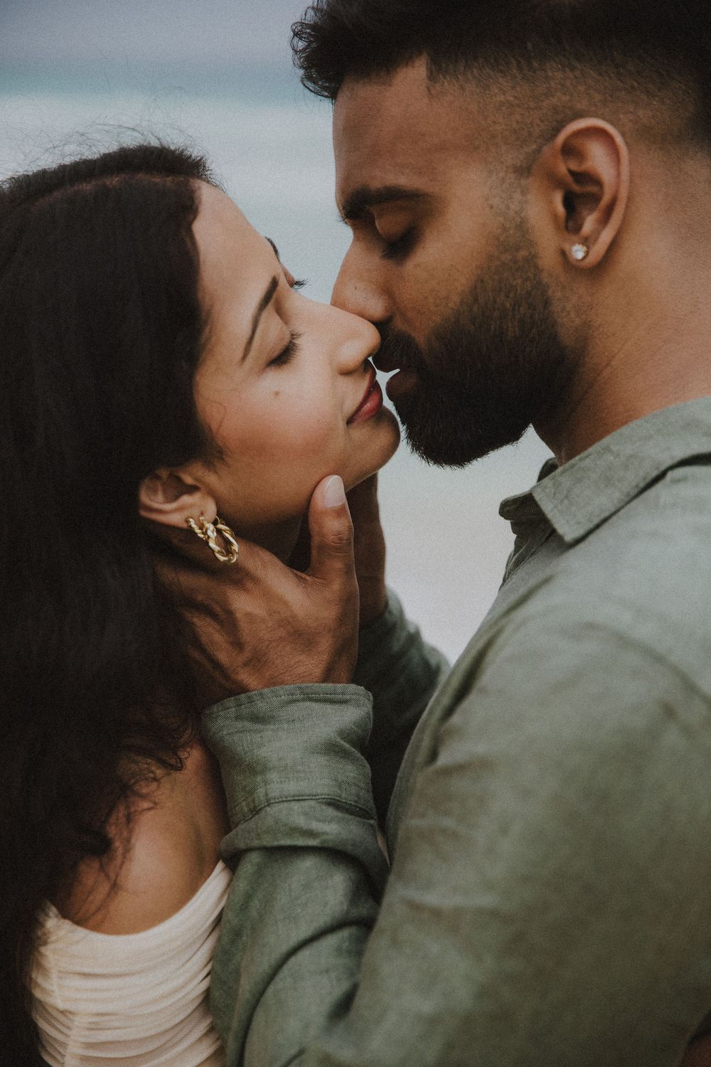 Romantic couple shares intimate close-up moments outdoors in a dramatic black and white photo series.