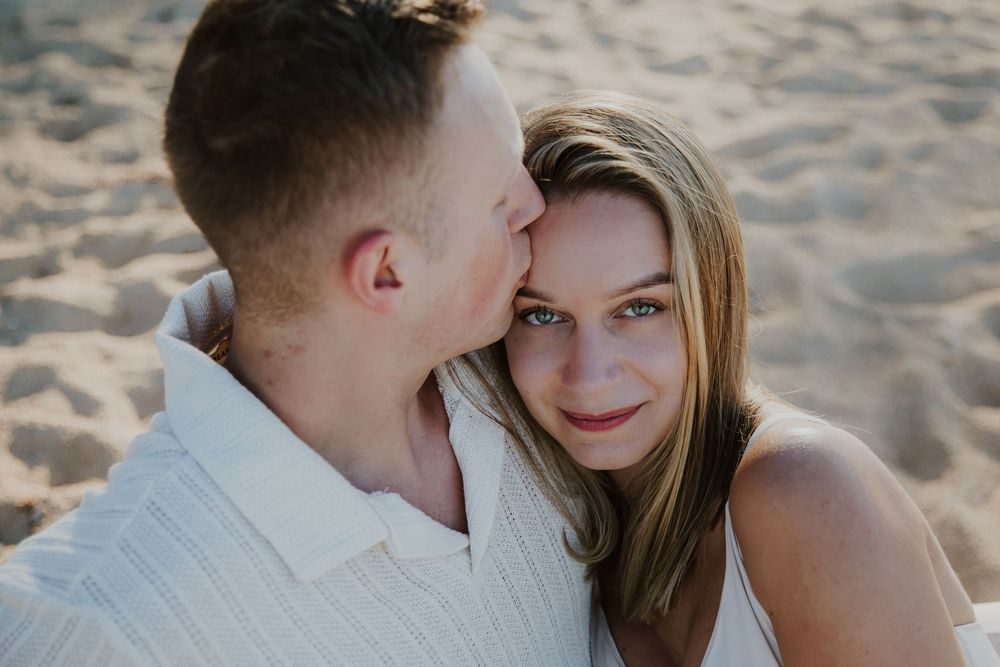 An intimate beach portrait captures a tender moment between a couple.