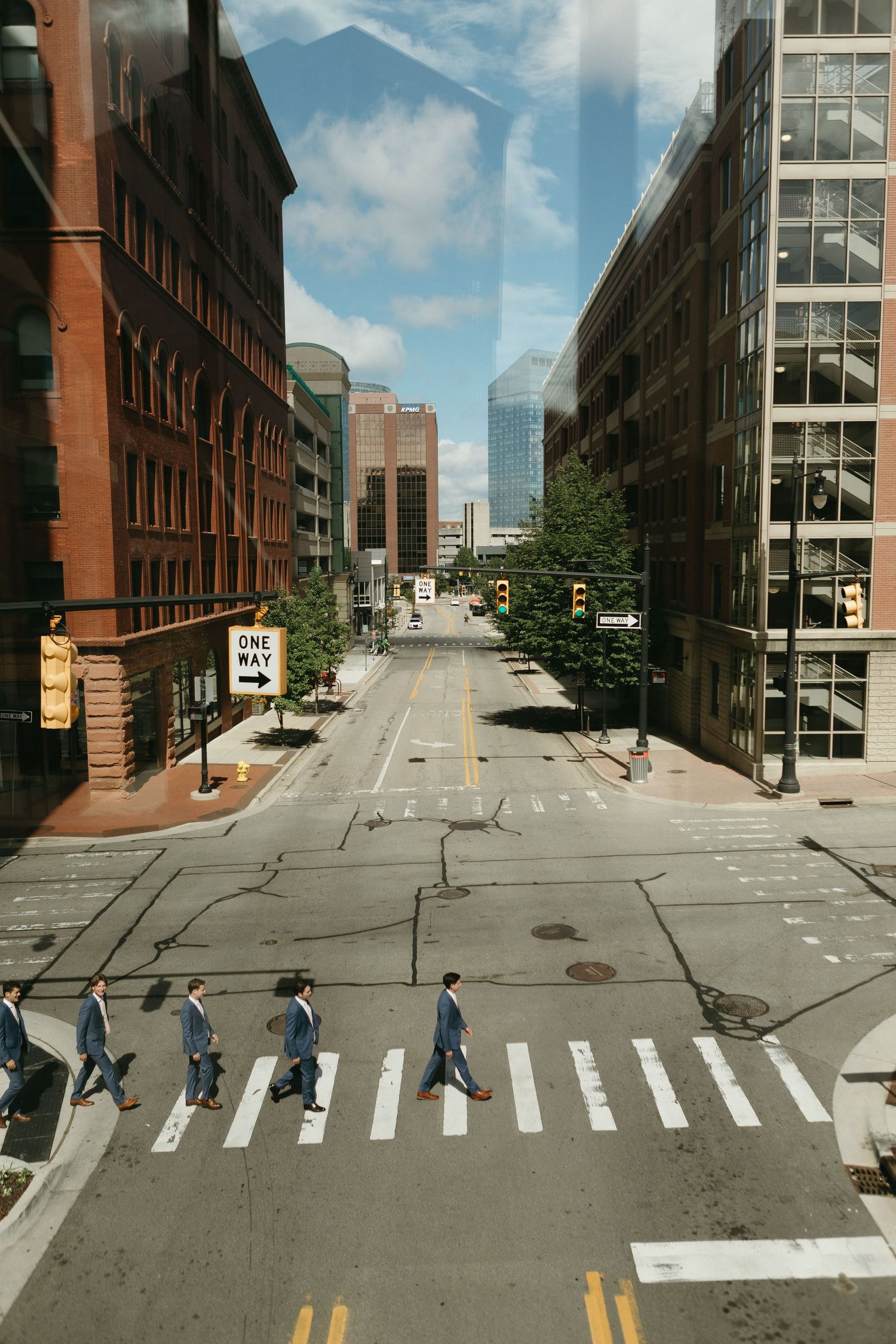 Urban street scene with classic brick buildings and mountains visible in the distance.