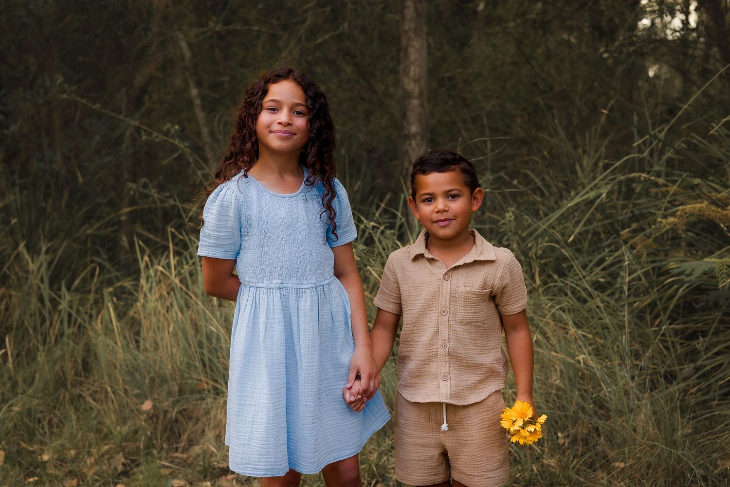 Playful kids running and laughing in a shaded, bushy spot in Nanango, South Burnett, during a fun candid photoshoot