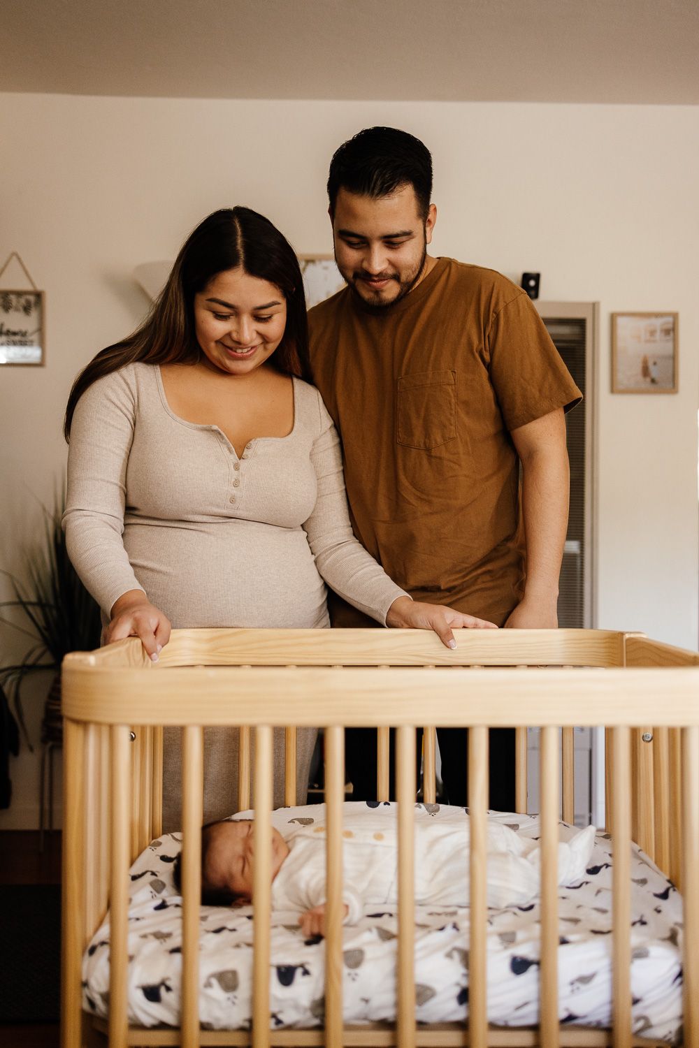 Parents lovingly look at their sleeping baby at in-home newborn photoshoot by Bay Area Photographer Cindy Tucey