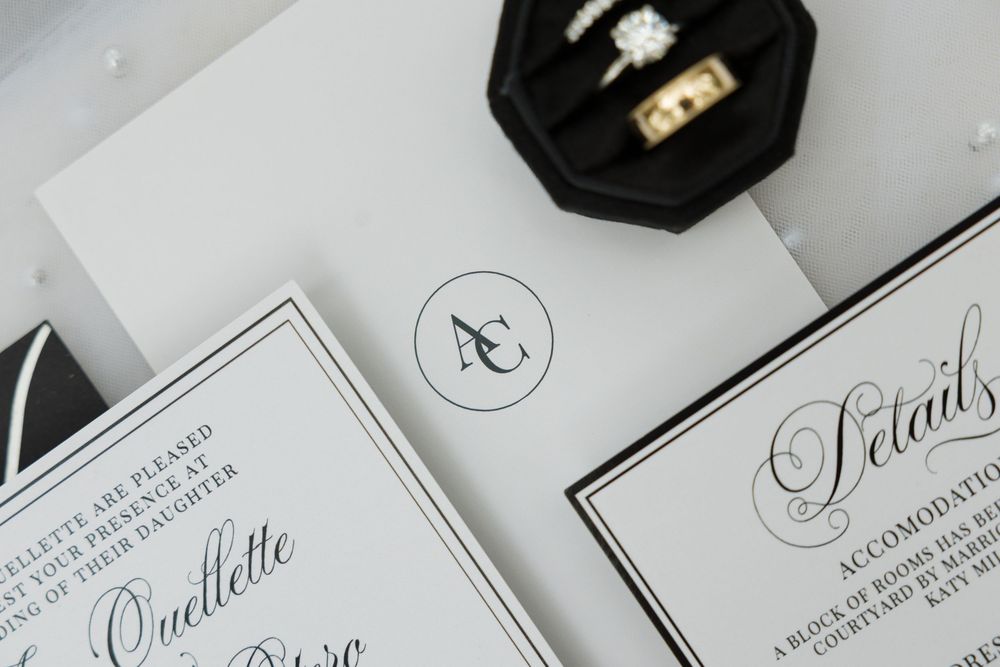 Elegant wedding stationery suite with monogram initials and diamond engagement rings.