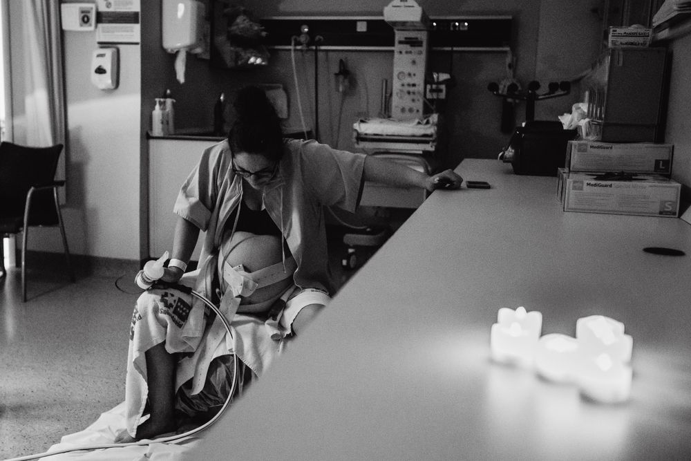 Hospital room scene showing quiet moments after birth in monochrome.