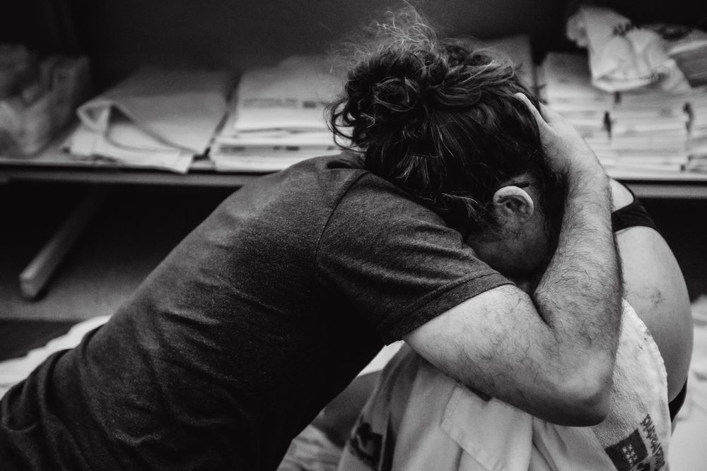 Black and white intimate birthing moment captured in documentary style.