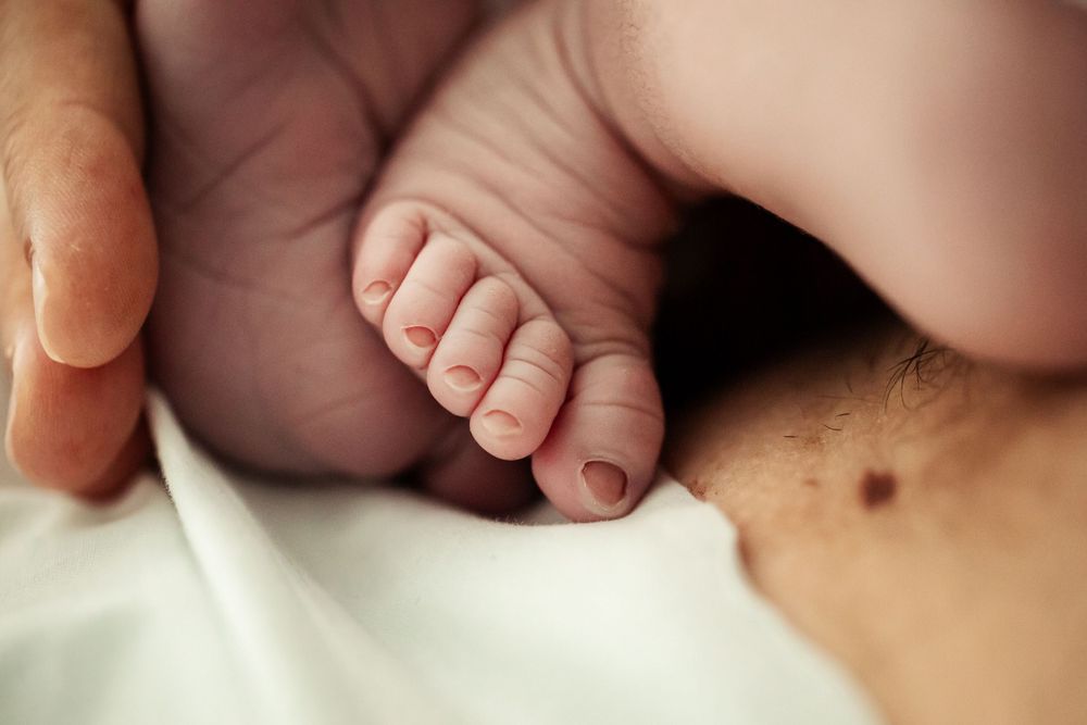 Close-up detail of newborn baby's tiny feet and toes.