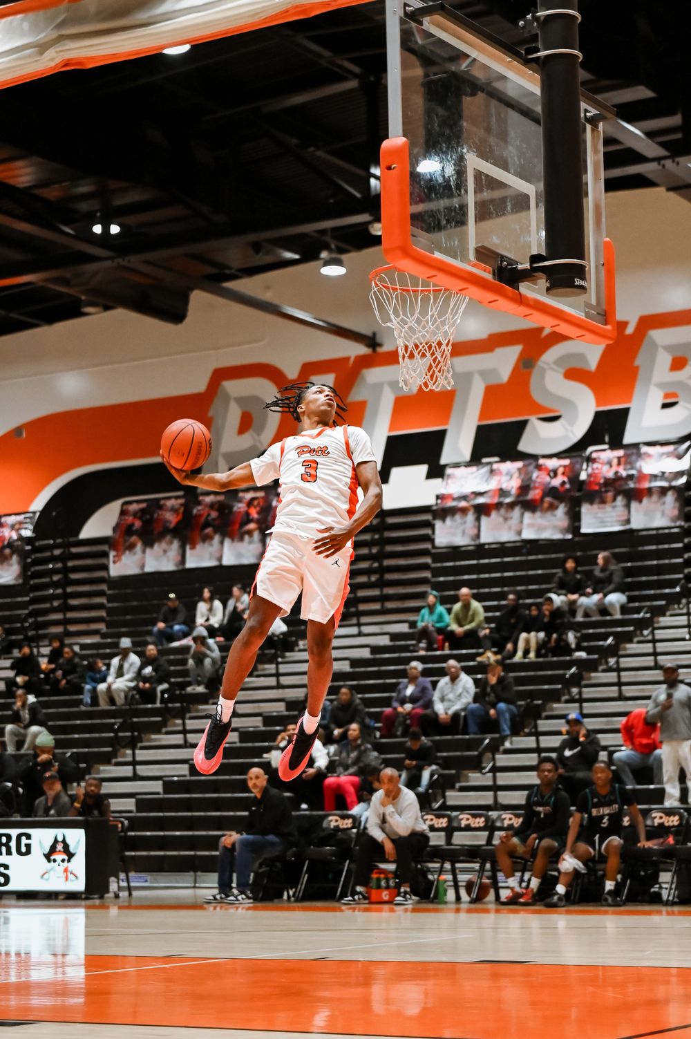 Basketball players demonstrate their vertical leap abilities during an intense game sequence.