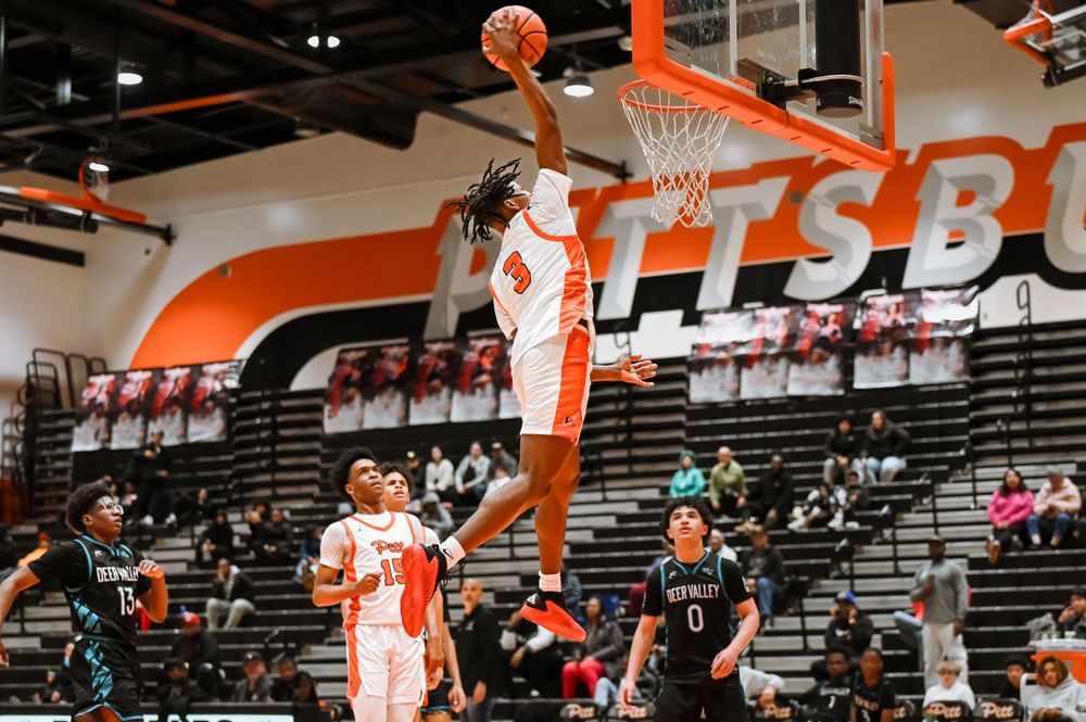 Players in orange jerseys display their athletic abilities during a basketball game on their home court.