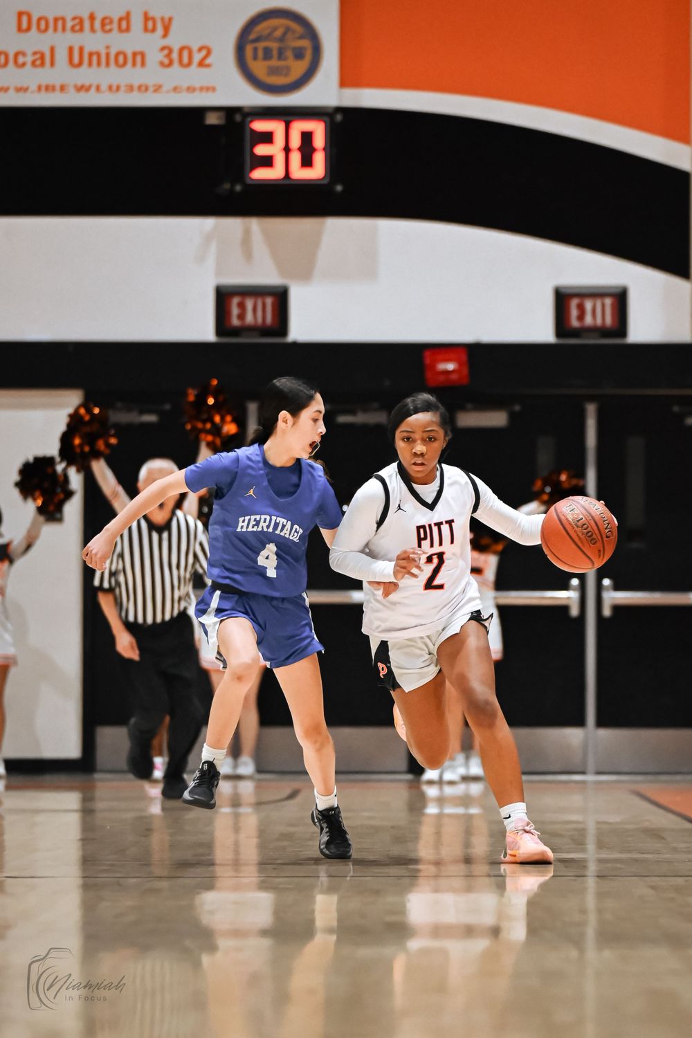 Basketball players from opposing teams compete during a game with scoreboard showing 30 points.