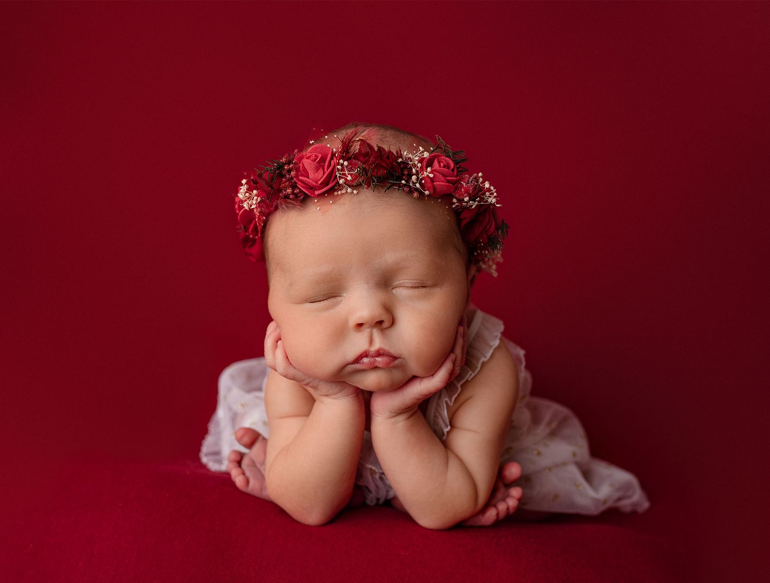 A professional captured newborn in a popular froggy pose, highlighting their peaceful expression and tiny details