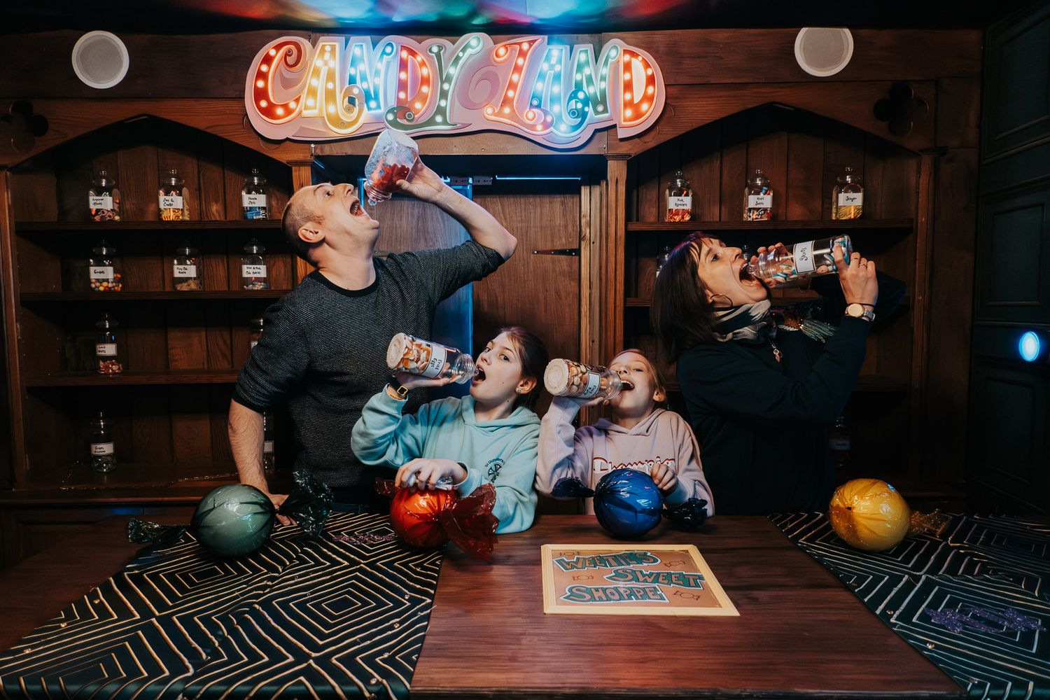 Group enjoying drinks and bowling together at a retro-styled bowling alley bar.