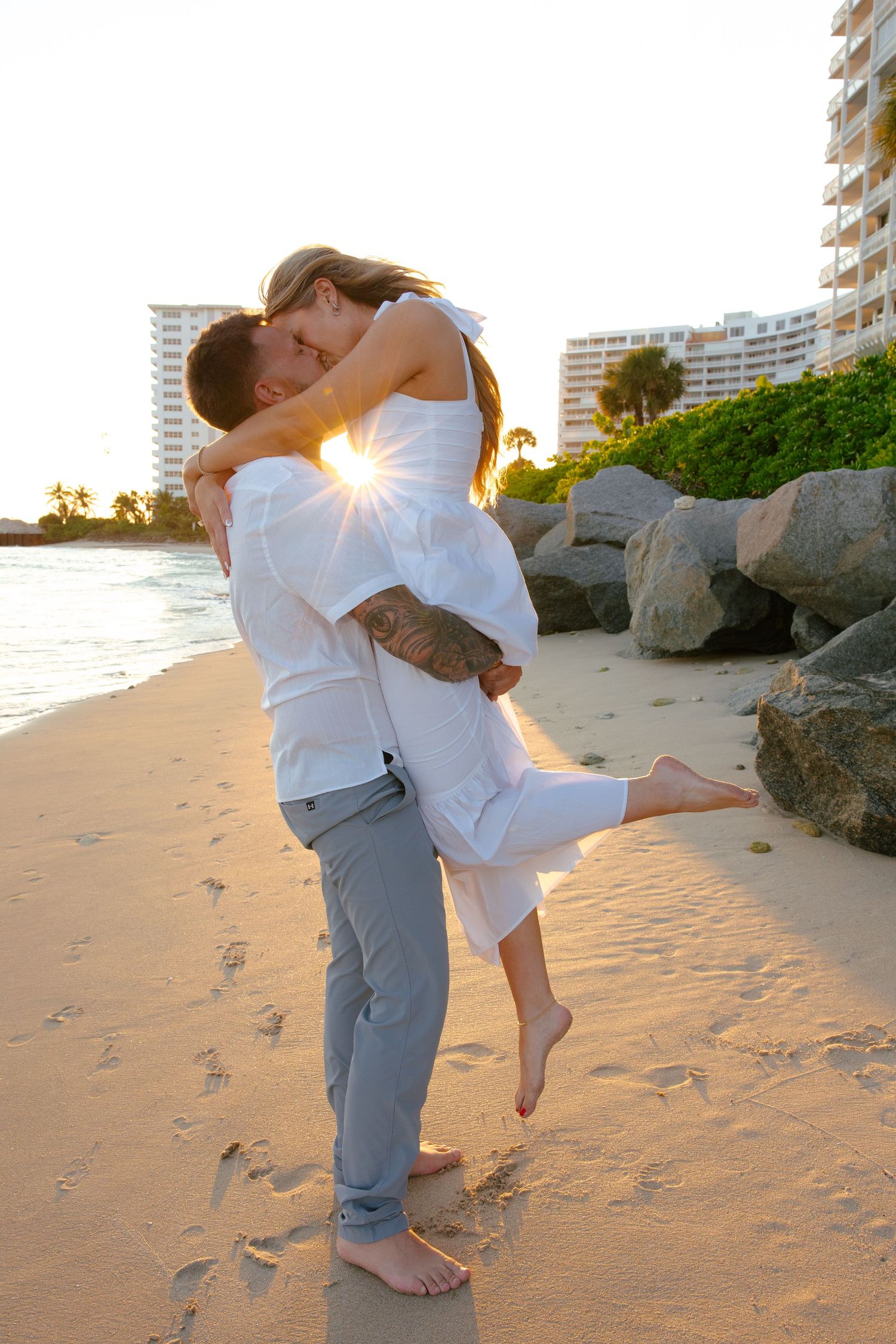 gorgeous, editorial style engagement photoshoot picture at Fort Lauderdale beach with sun flare coming through couples faces