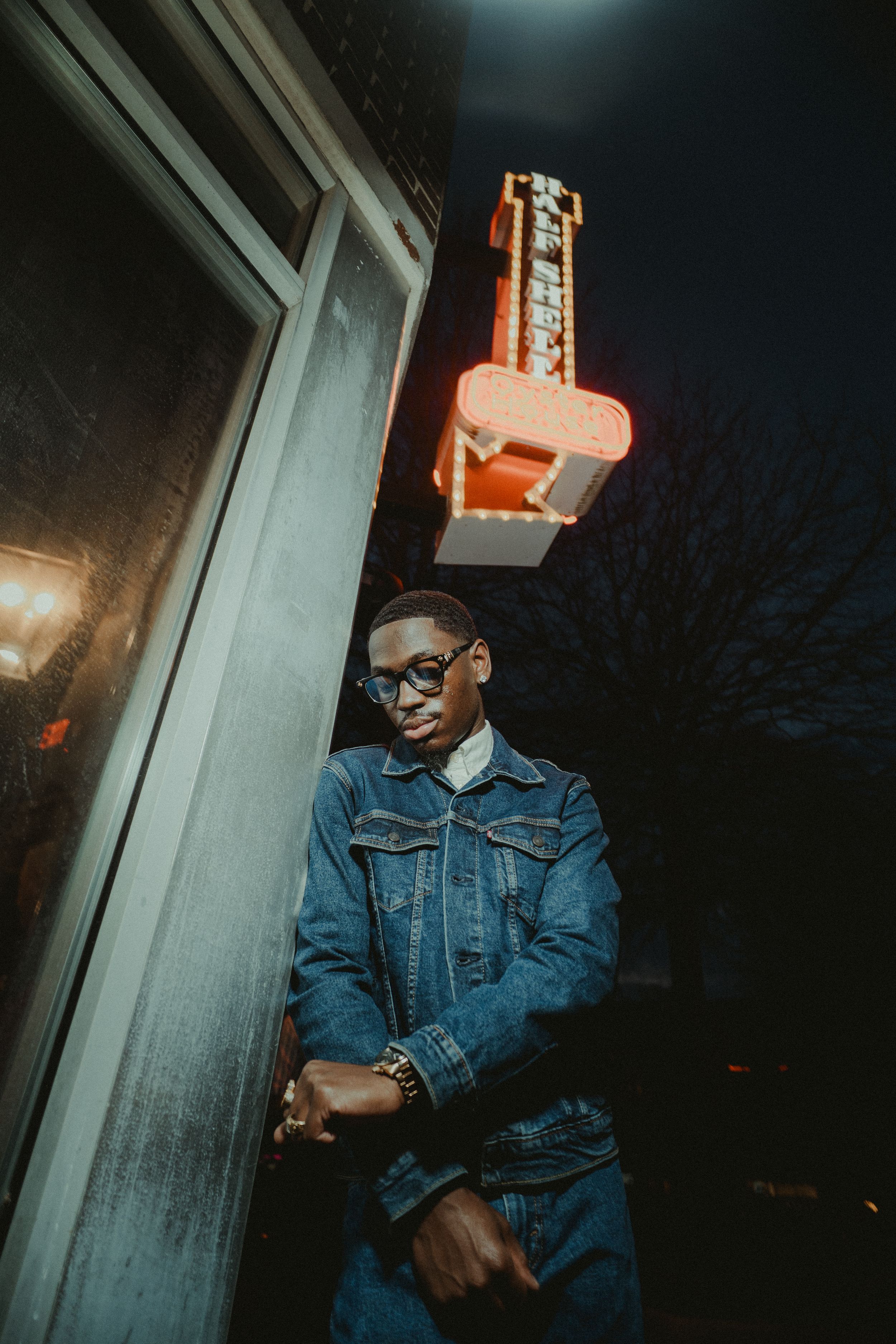 Moody portrait series showing a person in denim jacket against a window in dramatic low lighting.