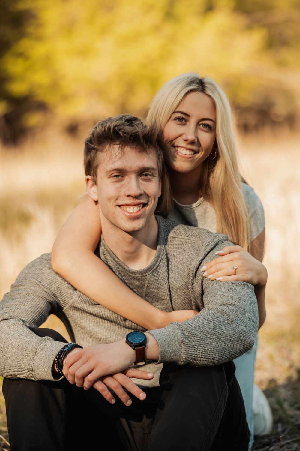 A couple shares intimate moments in a series of outdoor autumn portraits with golden bokeh background lighting.