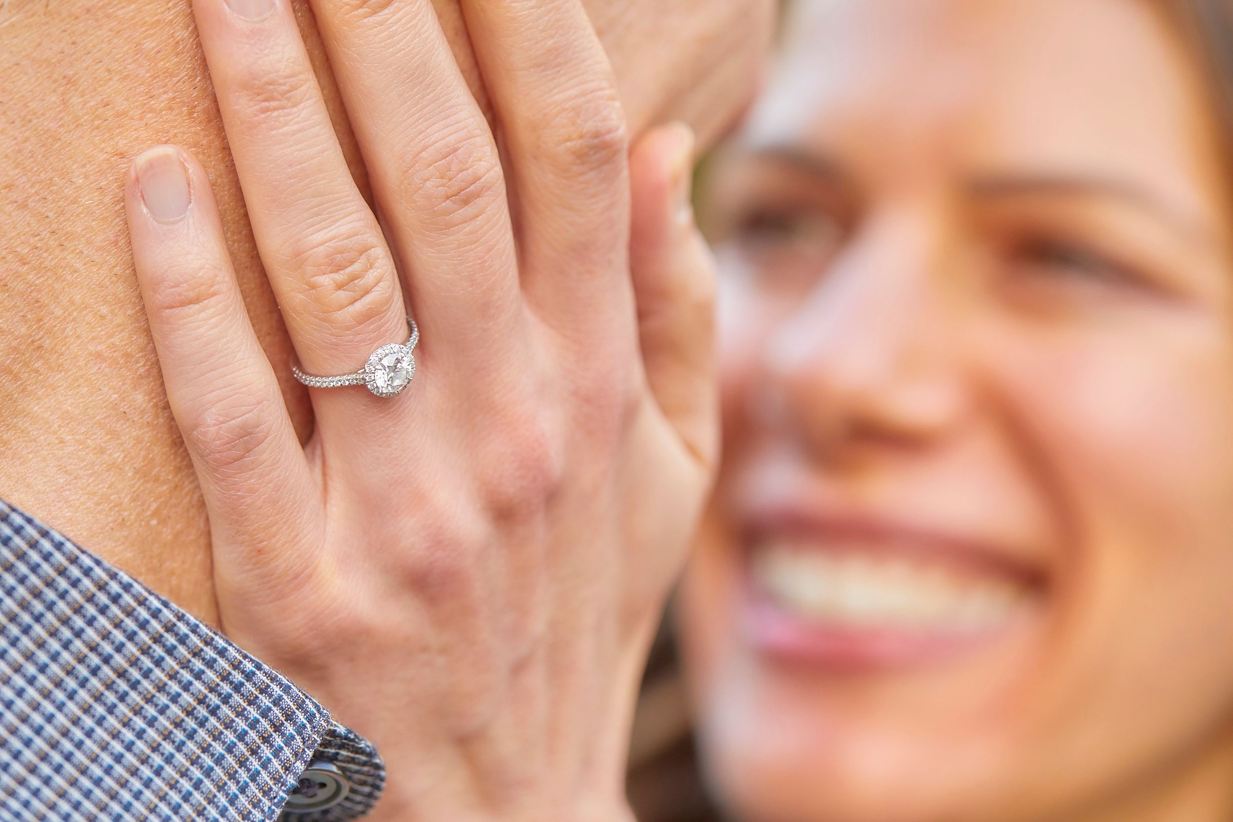Close-up of a sparkly diamond engagement ring with soft focus background.