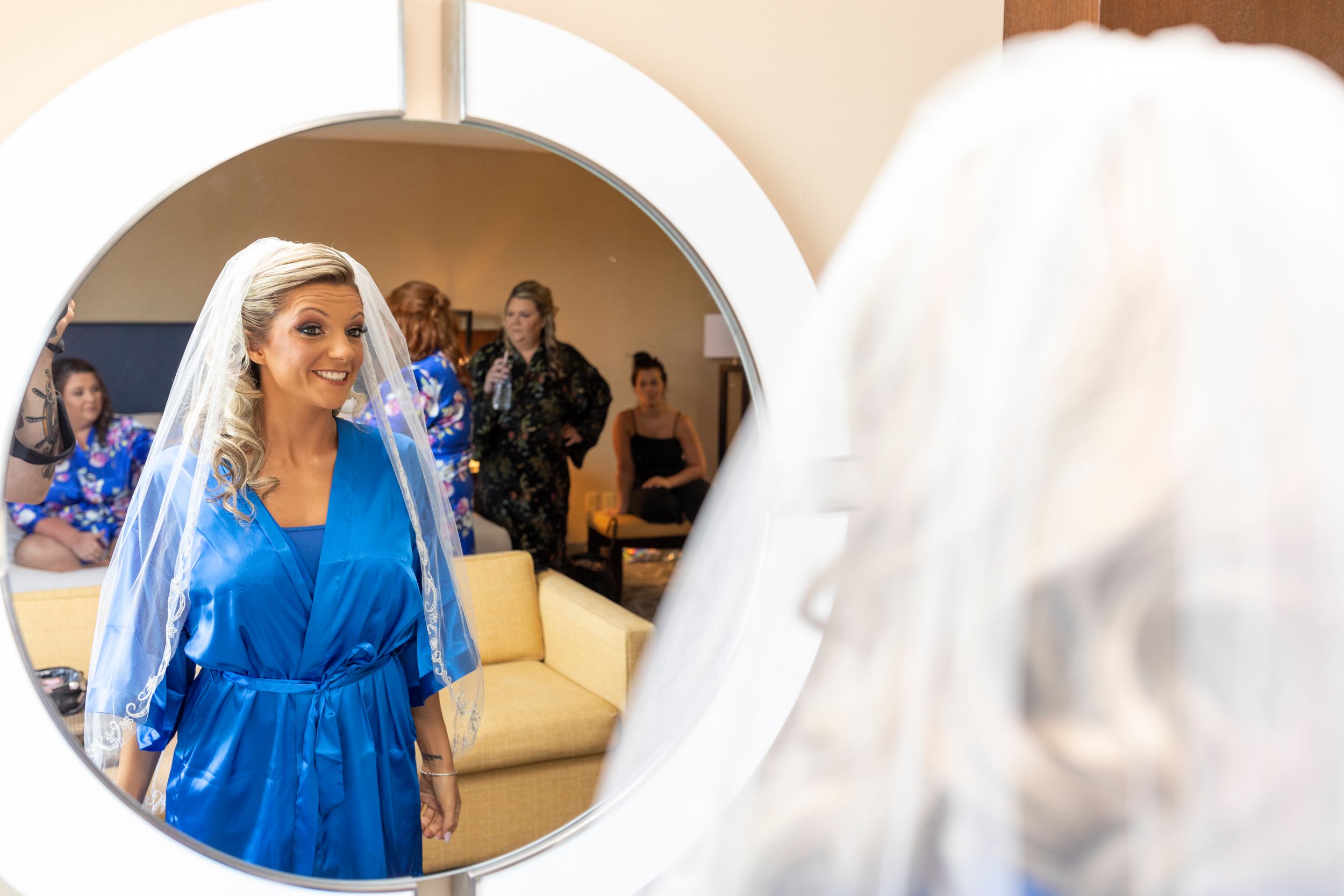 A wedding preparation scene with a mirror reflection in a sunny room.