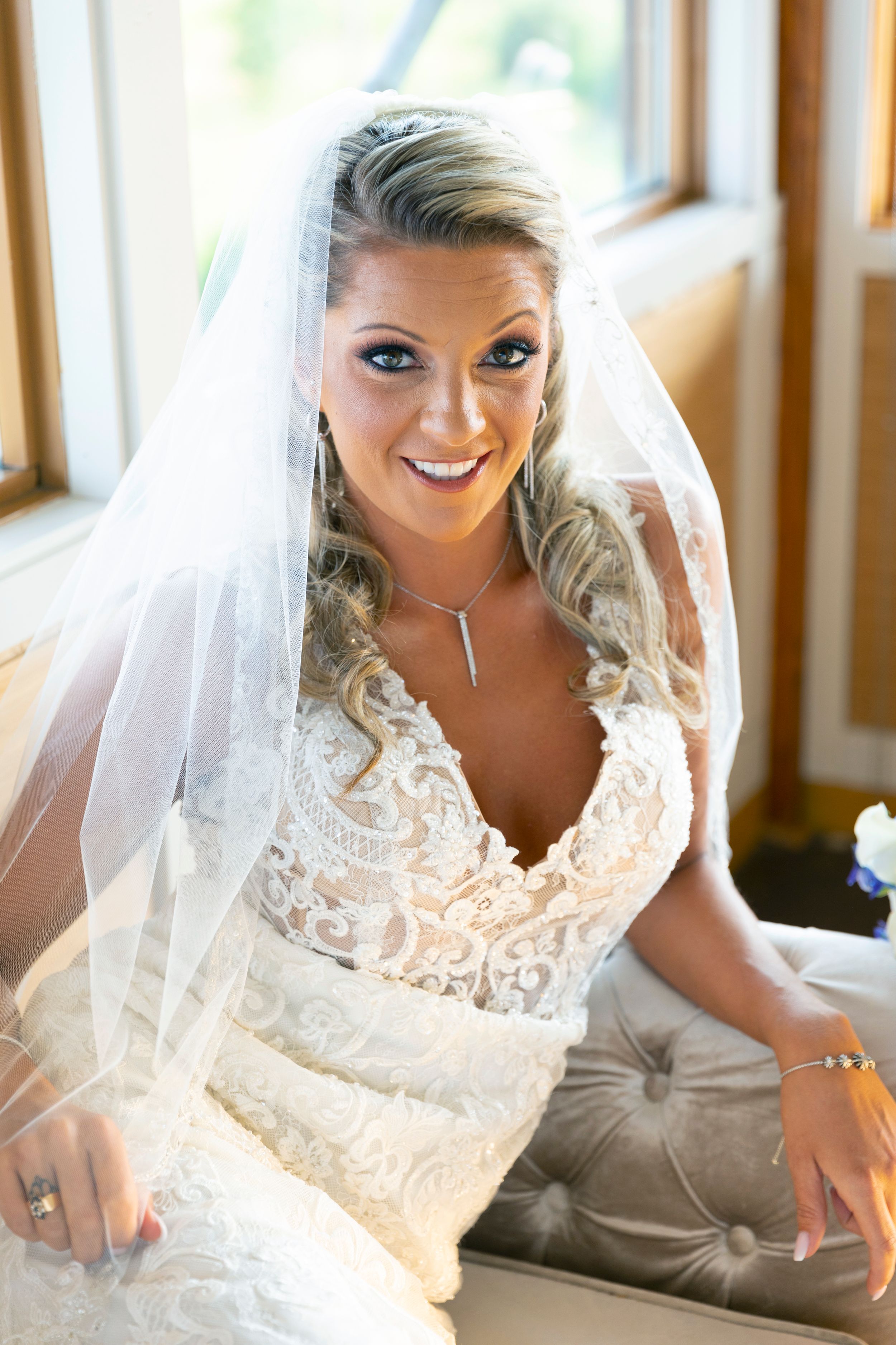 Elegant lace wedding dress and veil in warm natural light.