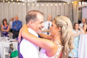 A candid reception dance moment captured with guests in the background.