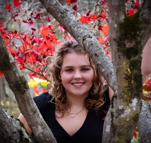 Close-up outdoor shot with bright red maple leaves in background.
senior photography