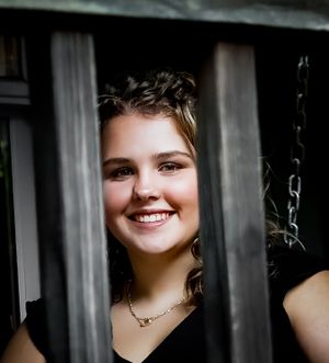 Portrait through window frame with dramatic lighting.
senior photography