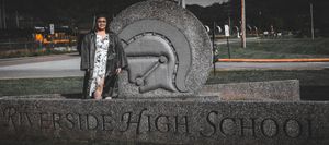 A student stands beside a large circular stone emblem at a high school entrance.
senior photography
Riverside High school
Kanawha county sch