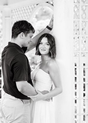 Romantic couple shares intimate moments in a white lattice gazebo setting.
