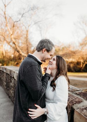 A romantic couple embraces on a stone path during golden hour.