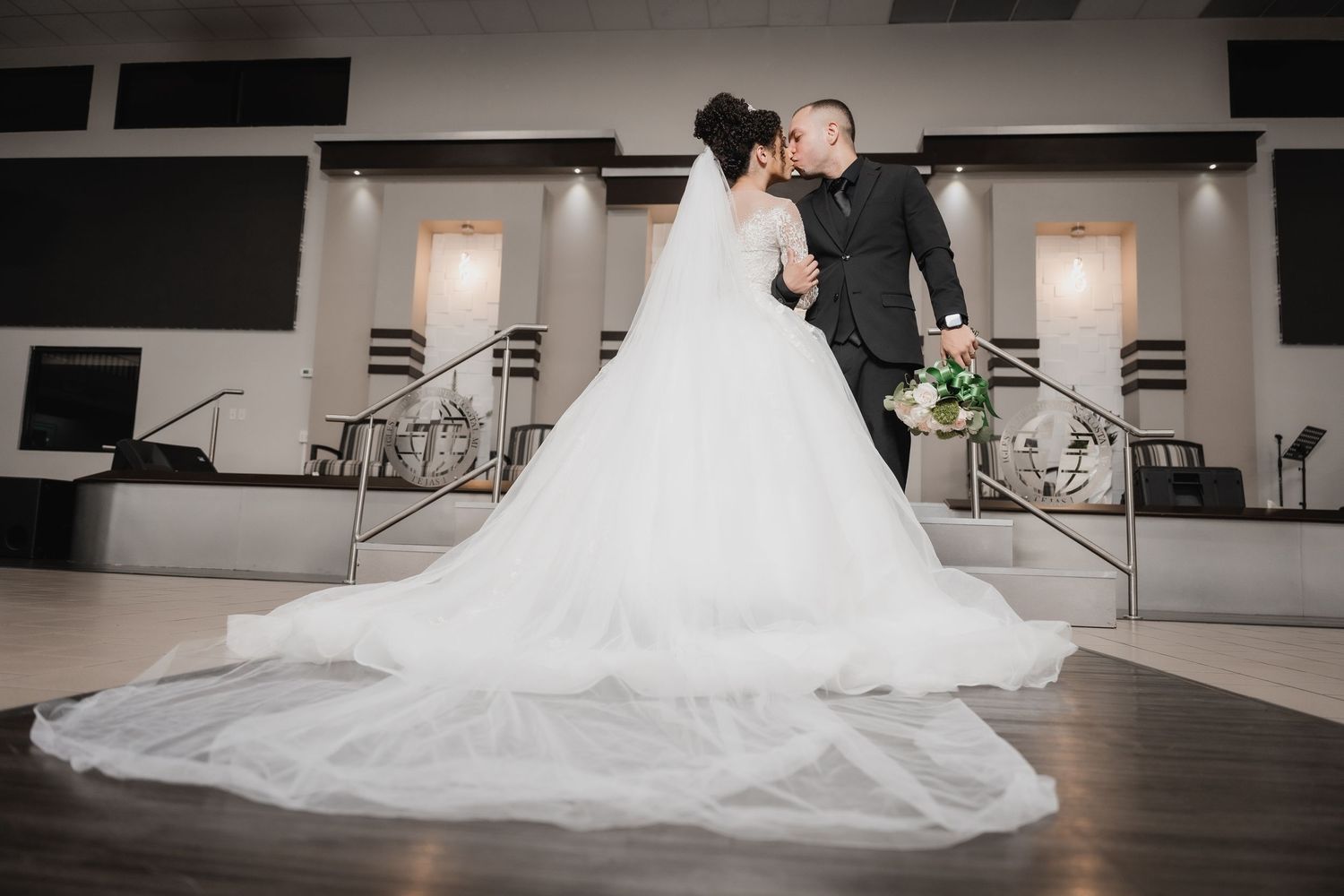 Elegant ballroom wedding photo showcasing dramatic train of white gown.