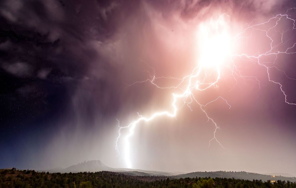Massive lightning bolt strikes near Sedona’s Cockscomb rock formation during monsoon season, captured by Chris Cornish Photography.