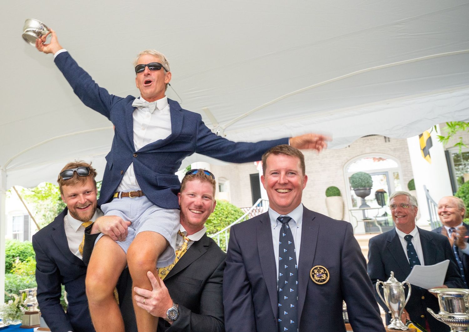 Celebratory moment at an outdoor event under a white tent with people in formal attire | photo by Tom McCall Photography | Maryland Film