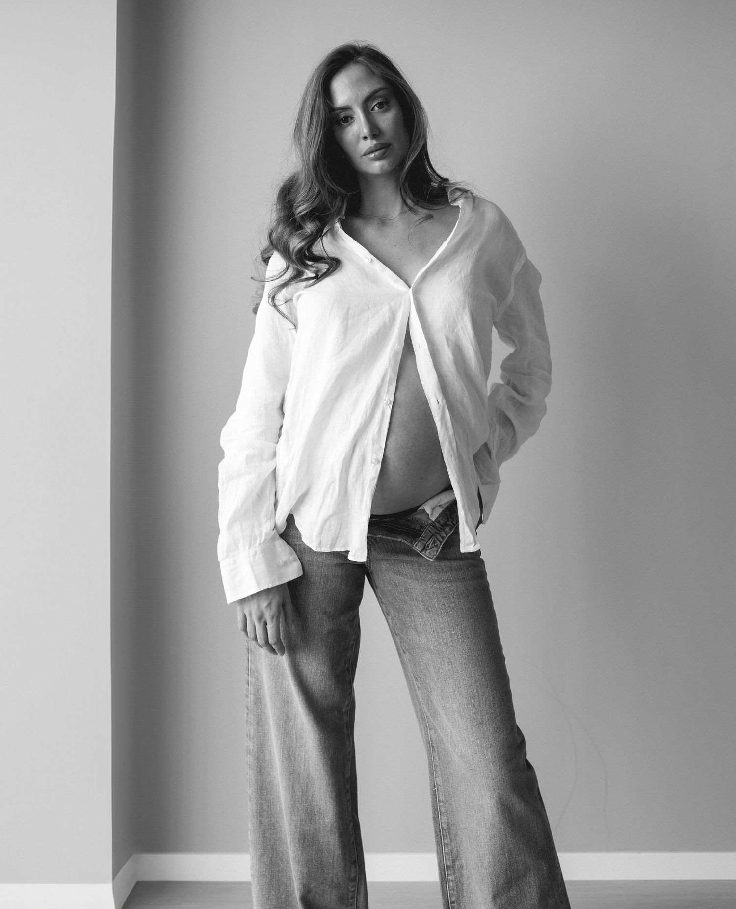 Gravidfotografering av @aida.bambina klädd i vit skjorta och baggy jeans