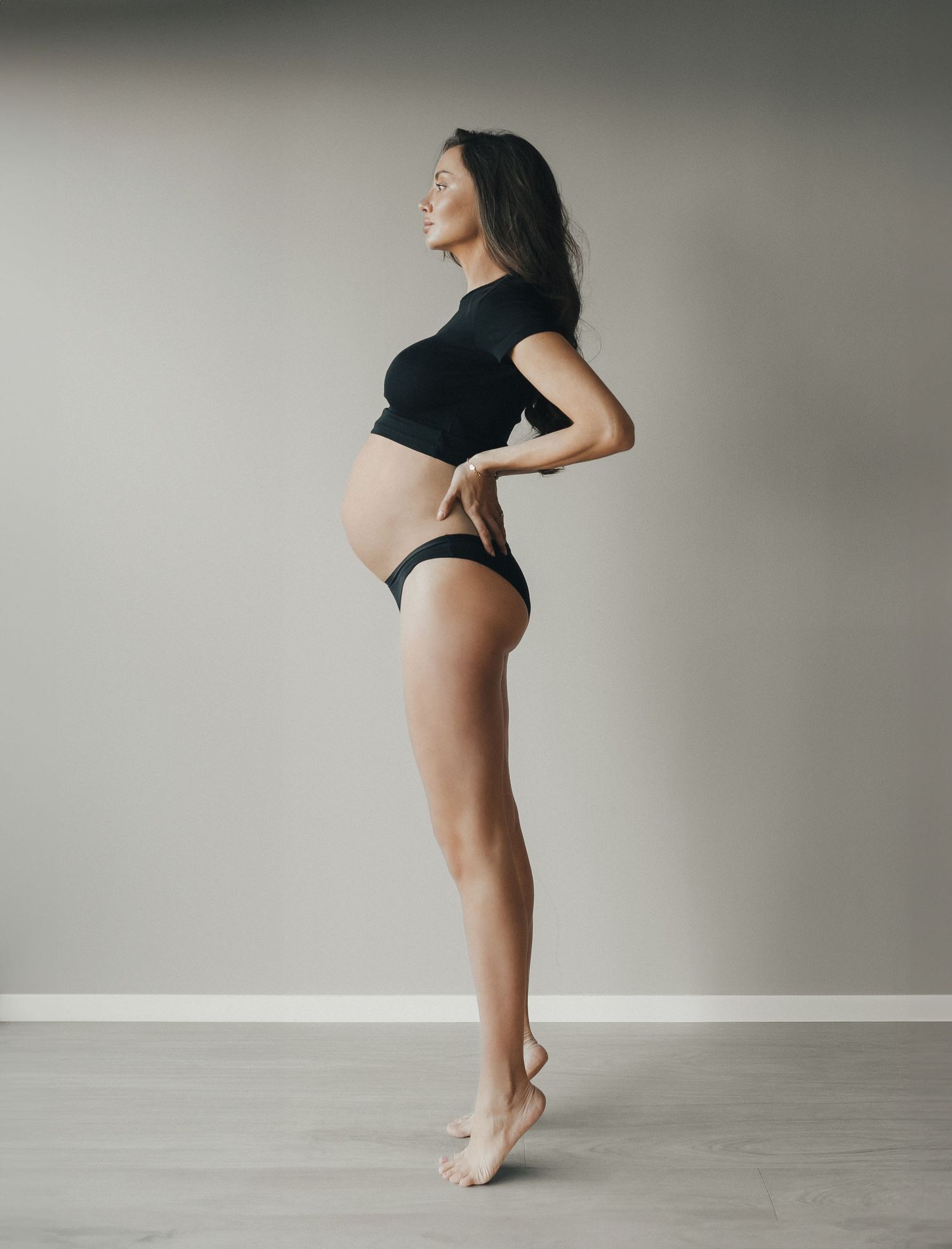 Gravid kvinna i hemmamiljö med naturligt ljus under gravidfotografering