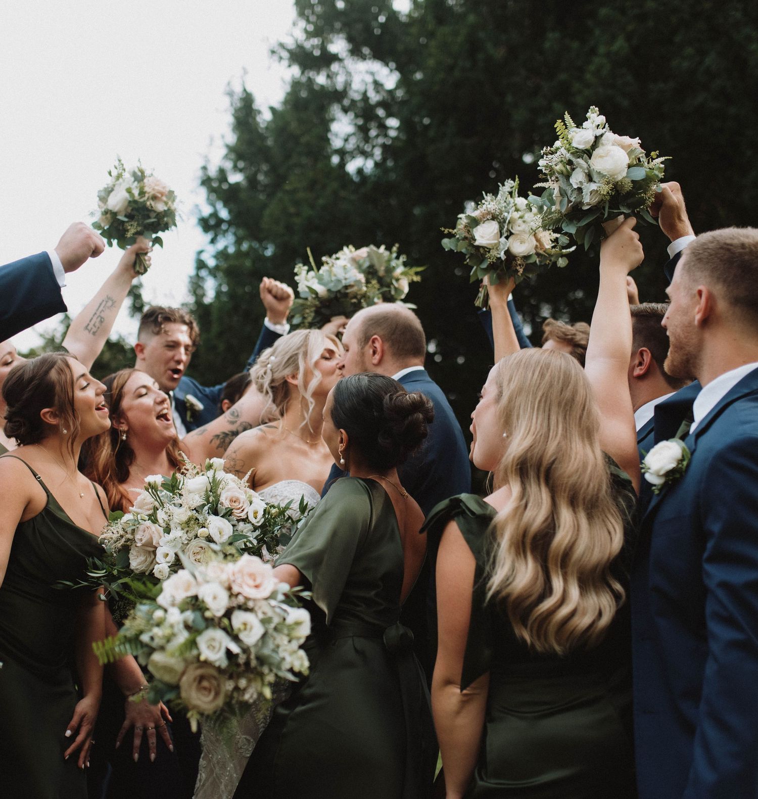 A couple shares a romantic moment under twinkling lights at a nighttime wedding celebration.