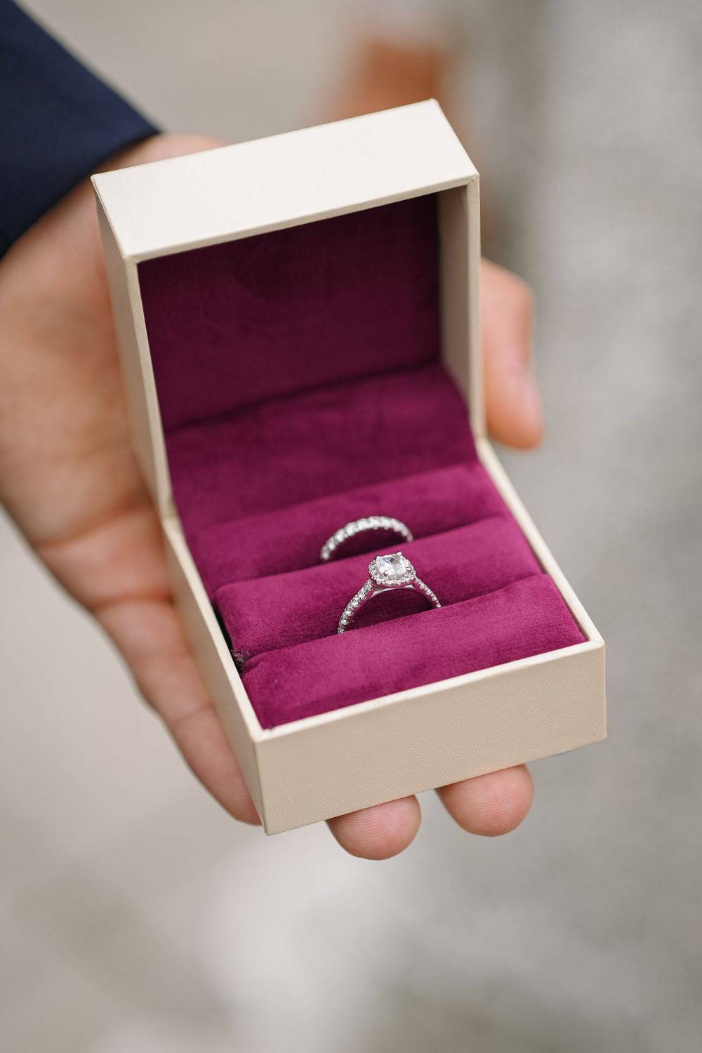 Five sequential photos show a silver engagement ring with a central diamond being revealed in a white box with burgundy lining.
