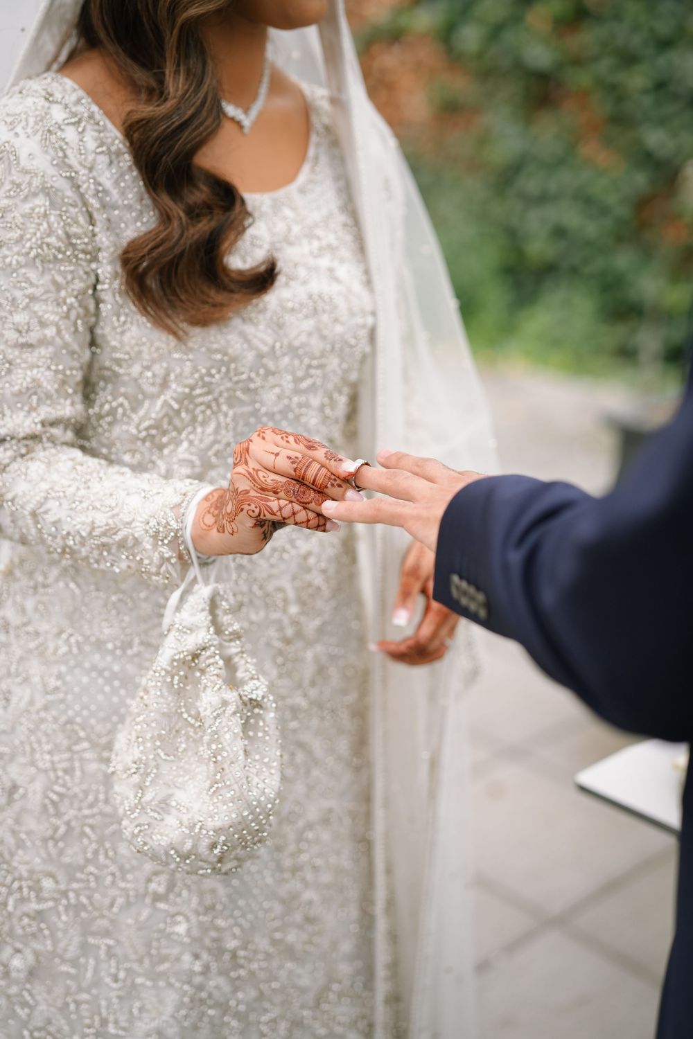 Close-up sequence showing hands exchanging wedding rings during an intimate outdoor ceremony.