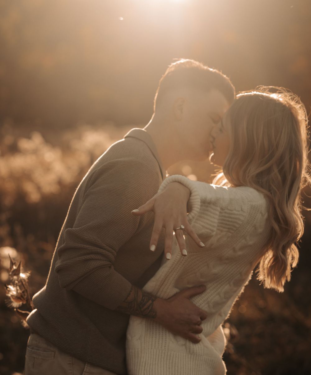 Couple sharing intimate moment in golden sunset light wearing cozy sweaters.