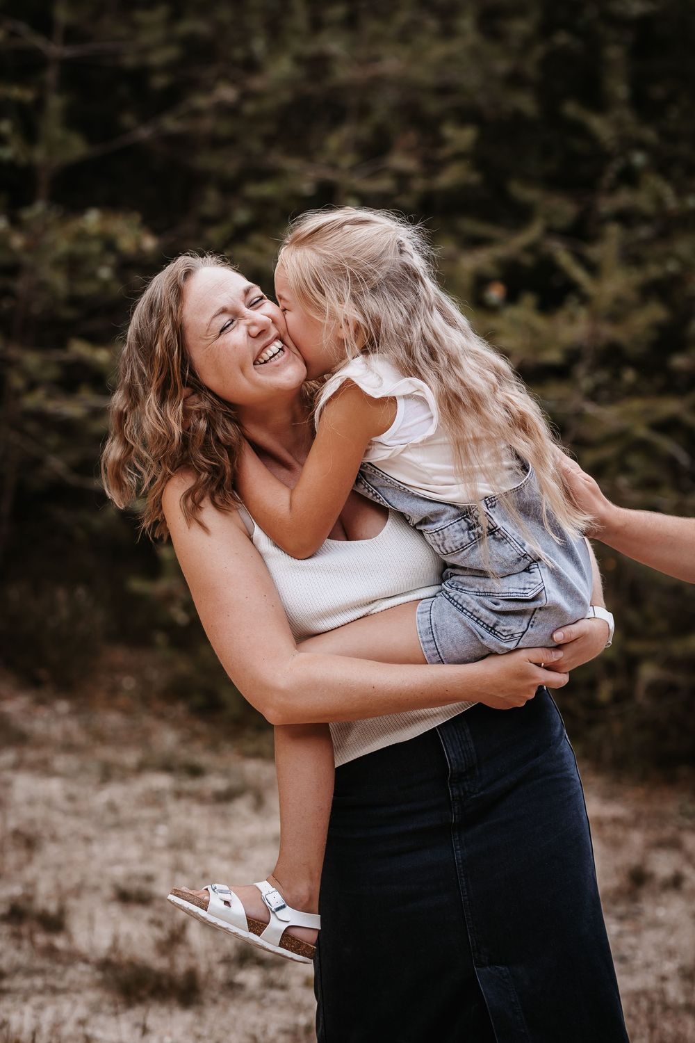 Playful outdoor family moment captured in natural lighting.