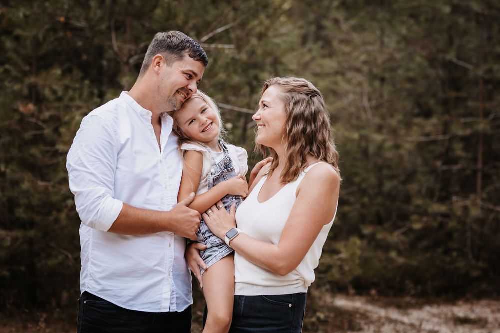 Candid family portrait session in a rustic outdoor setting.