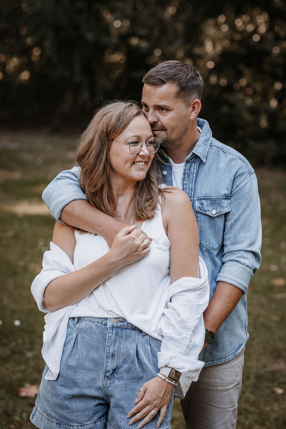 Casual couple sharing intimate moment outdoors in natural setting.