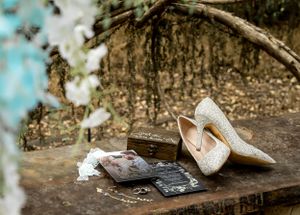 Wedding accessories including sparkly heels and jewelry arranged on a rustic wooden surface.