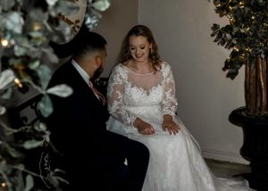 A romantic moment captured during a wedding ceremony with elegant floral decorations.
