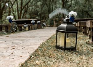 Black lantern with decorative flowers lines a garden pathway creating romantic ambiance.