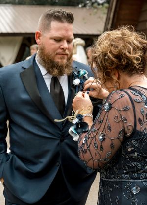 Emotional moment at wedding as couple pins boutonniere.