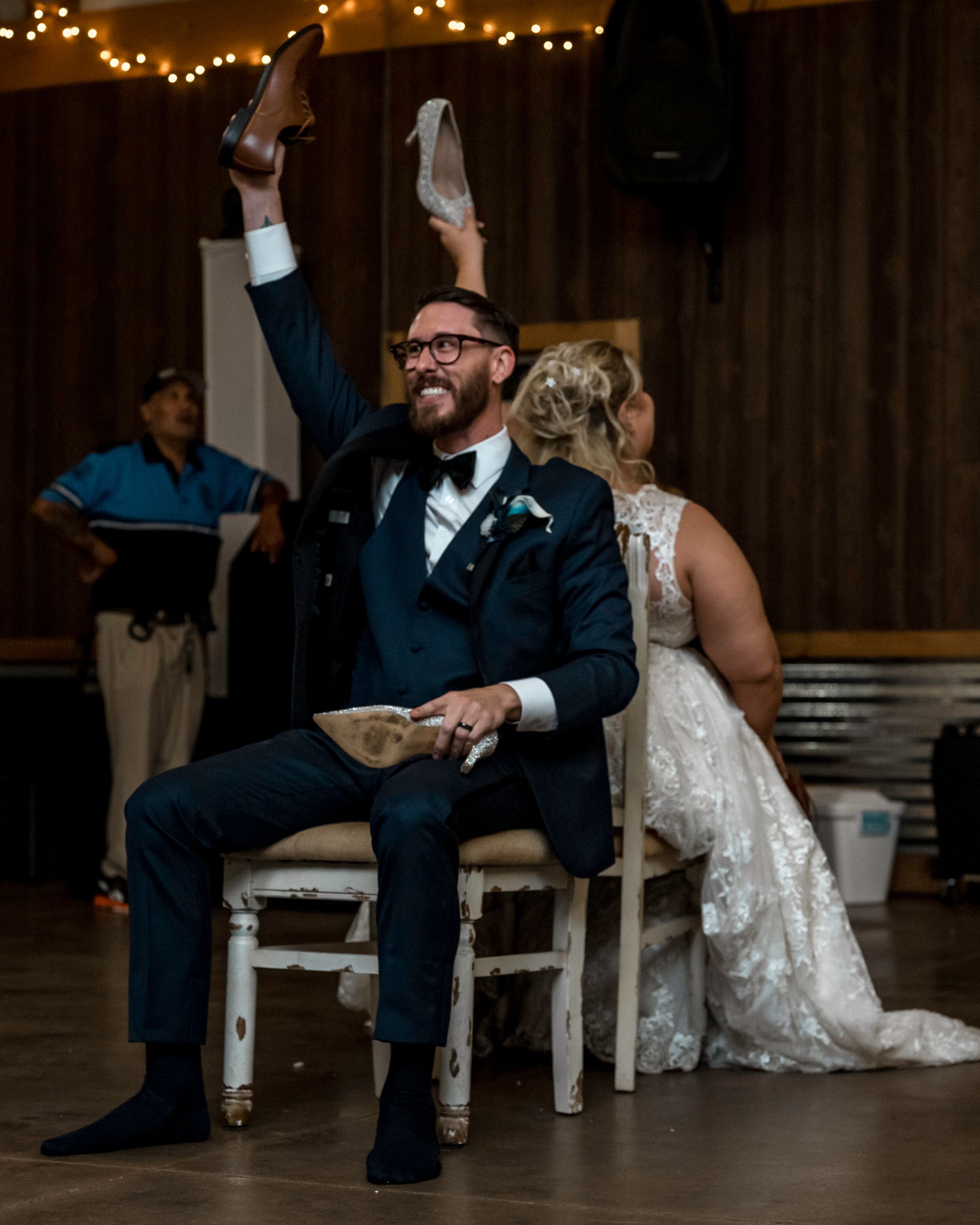 Couple participating in a fun wedding reception game with chairs.